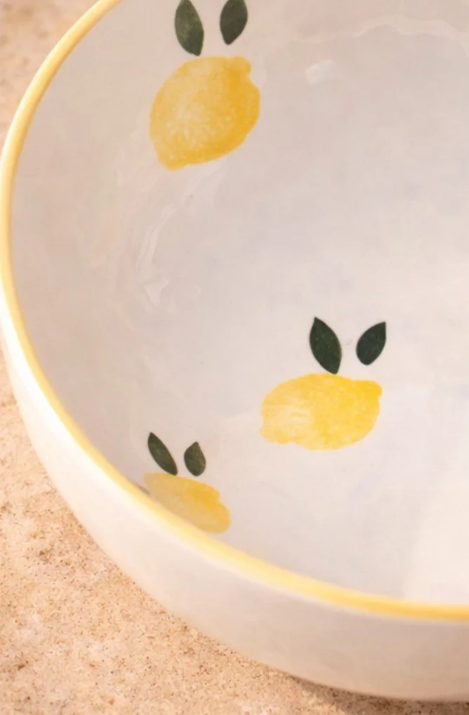 Détail des motifs citron peints à la main sur un saladier en céramique artisanale