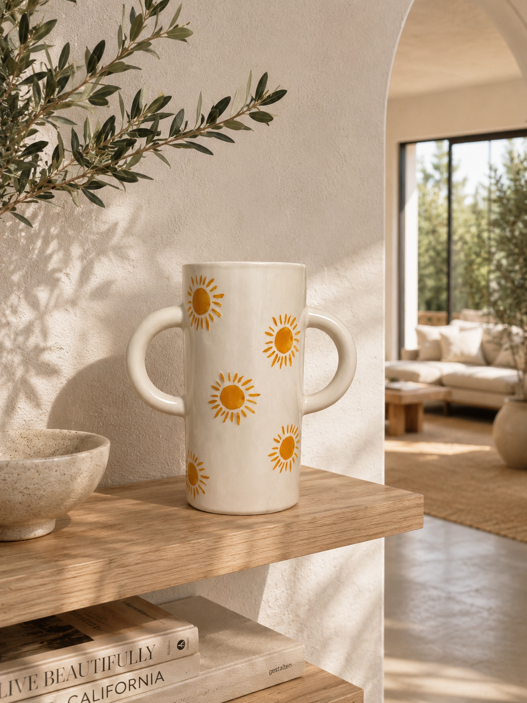 Vase soleil en céramique artisanale portugaise sur étagère en bois dans un intérieur lumineux d'inspiration californienne.