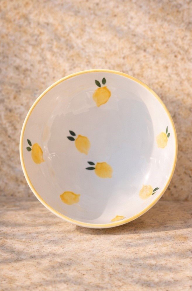 Vue intérieure d’un saladier en céramique artisanale avec motifs citron peints à la main