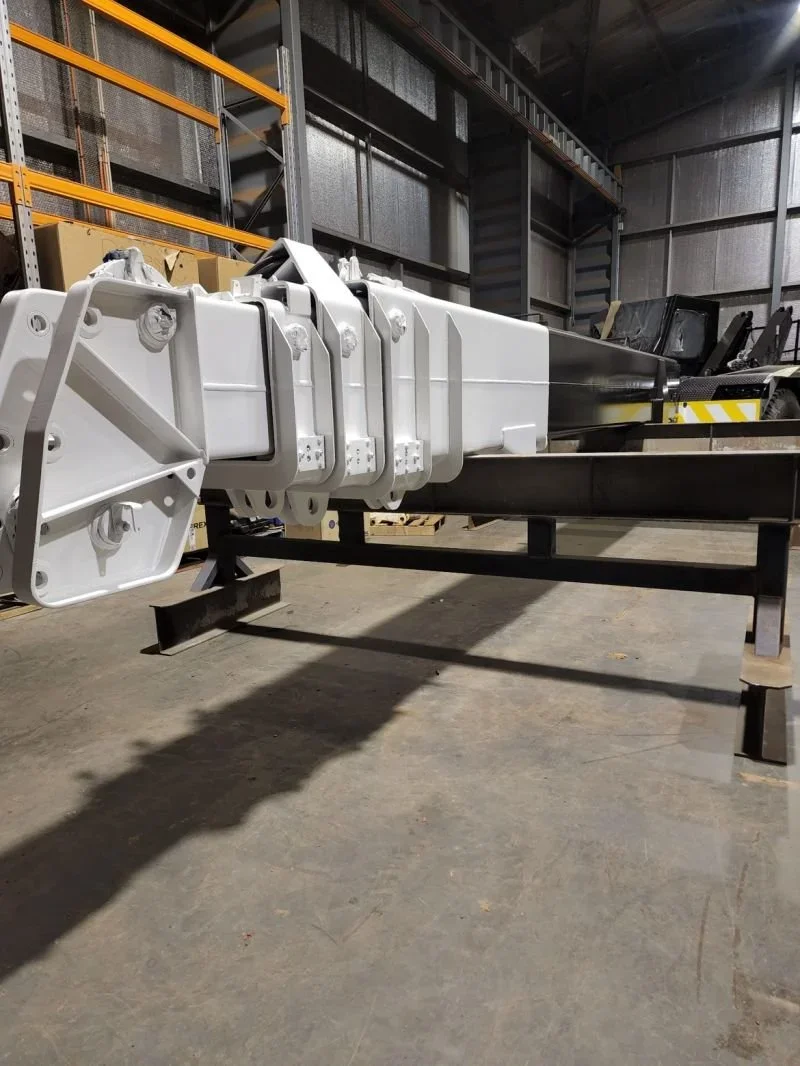 A large industrial piece of equipment or machinery inside a warehouse, with metal framework and shelving in the background.