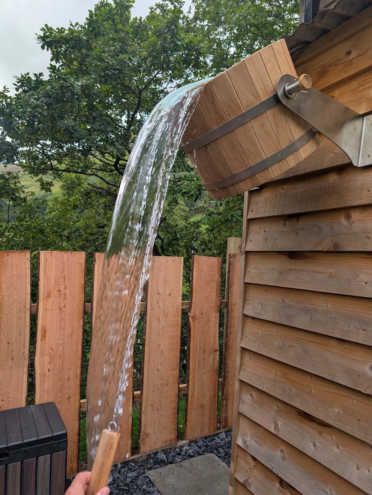 Refresh your senses during a sauna session with a cold plunge bucket shower located next to the outdoor sauna.