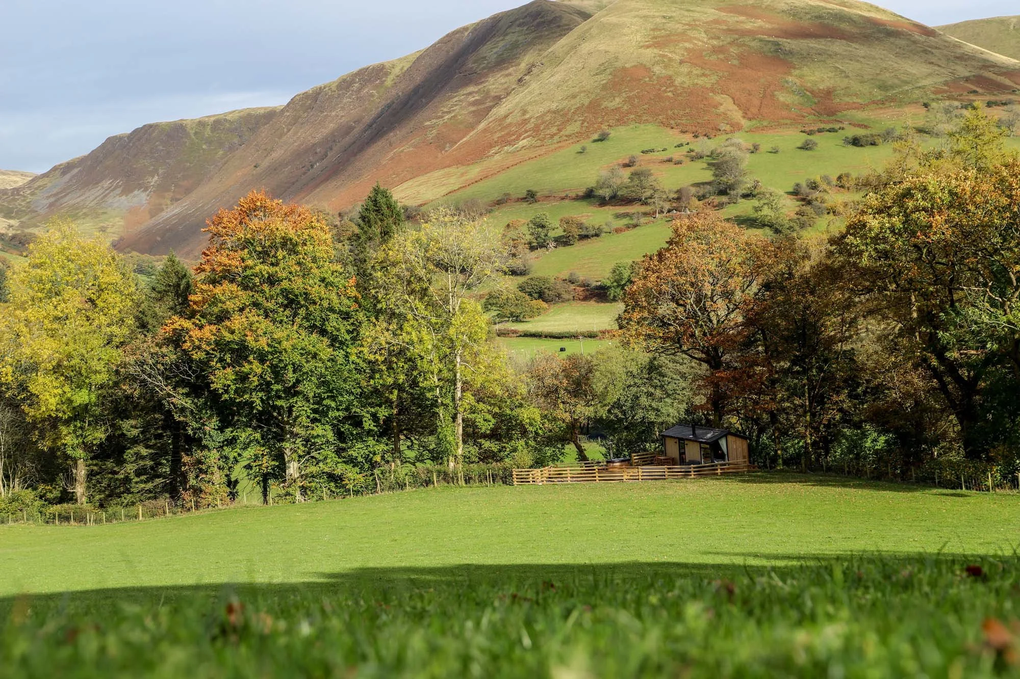 timber holiday cabin set within the lush green rolling hills and autumn trees of mid Wales and Eryri National Park, near Dinas Mawddwy.