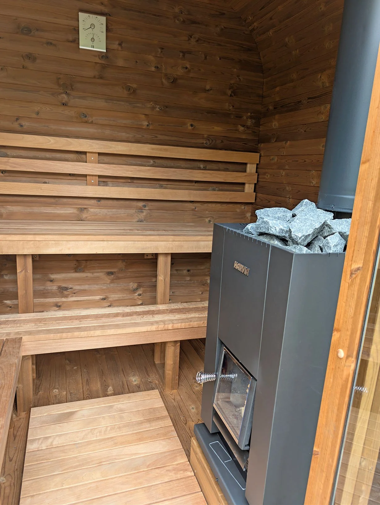 Modern wood-fired sauna stove in our compact and private outdoor sauna – perfect for couples to unwind after a day in the outdoors.