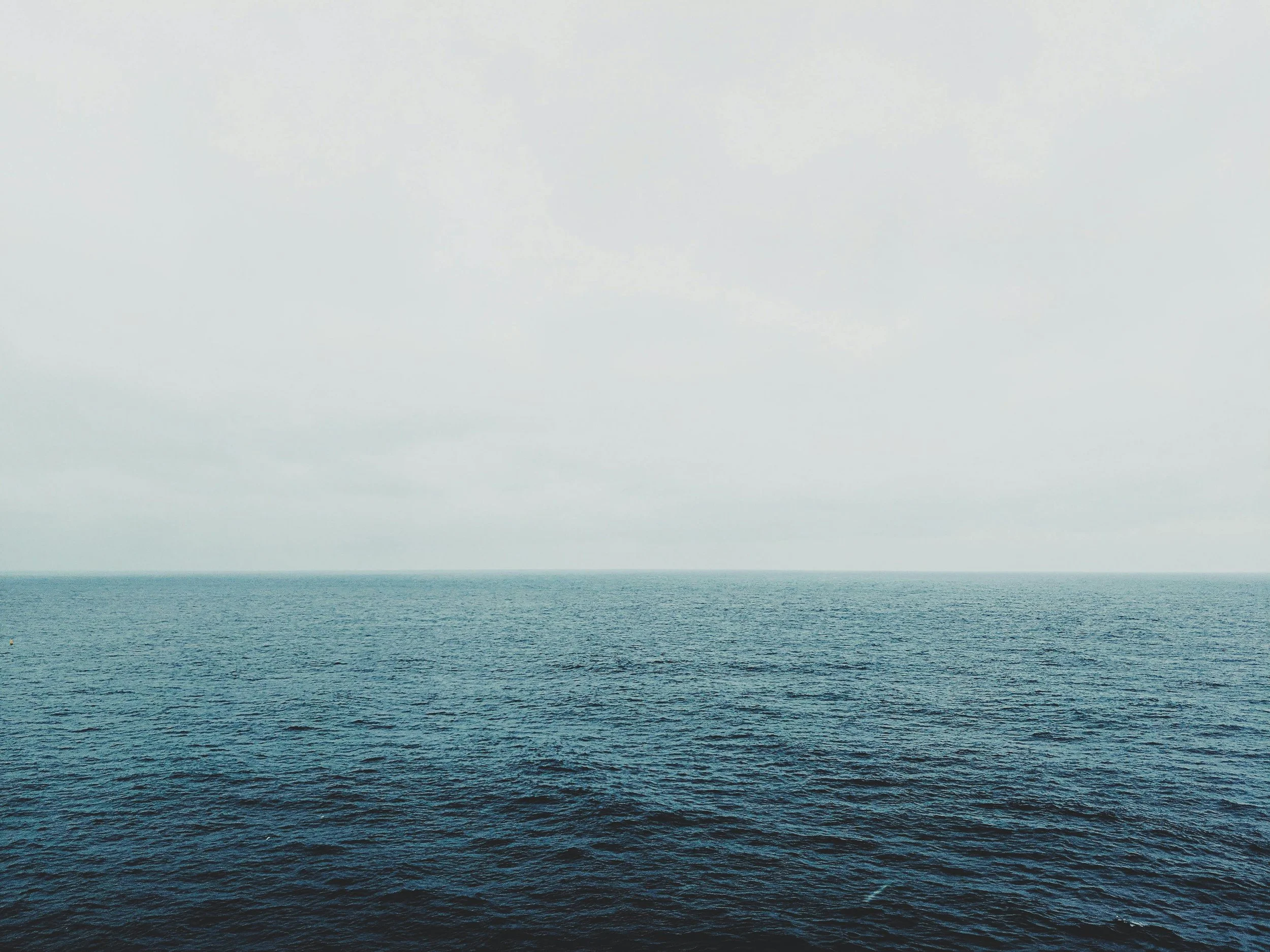 Calm ocean with a gray, cloudy sky above representing therapy support for children and overwhelmed parents in Massachusetts