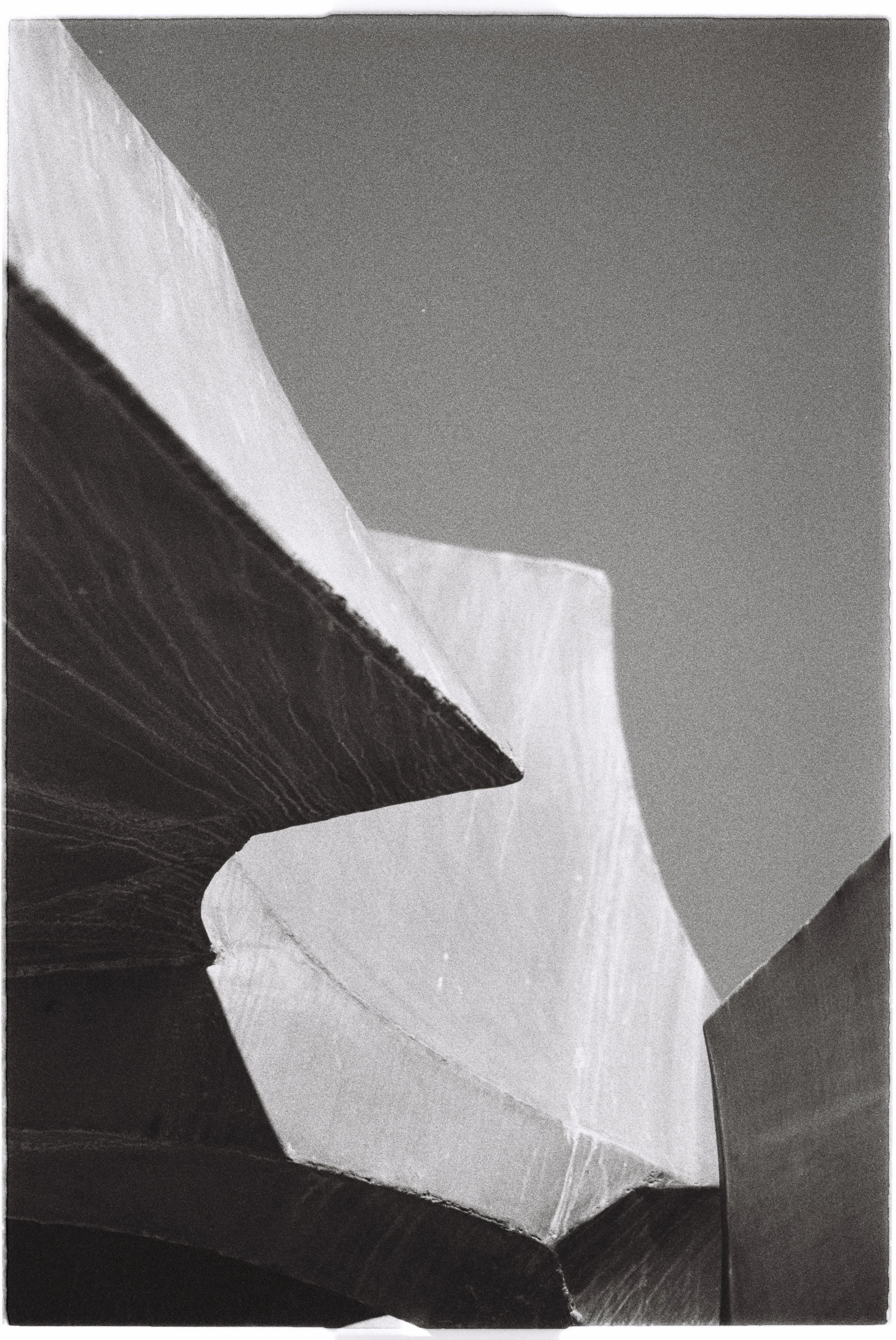 Close-up of abstract architectural structures with sharp angles and contrasting light and shadow.