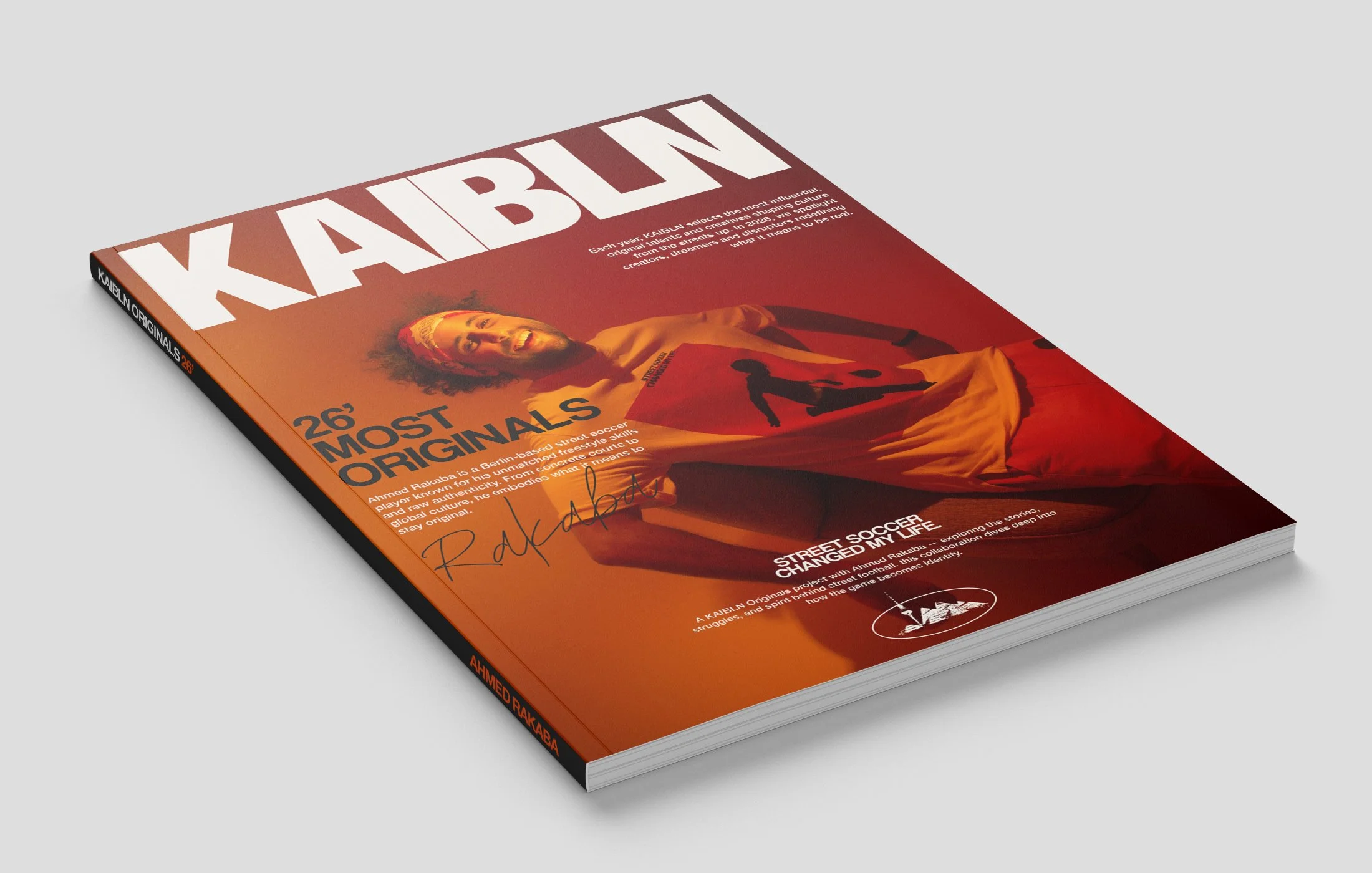 A magazine cover titled 'KAIBLN' featuring a woman with curly hair and a headband, holding a sign with a soccer player silhouette, in orange and red tones.