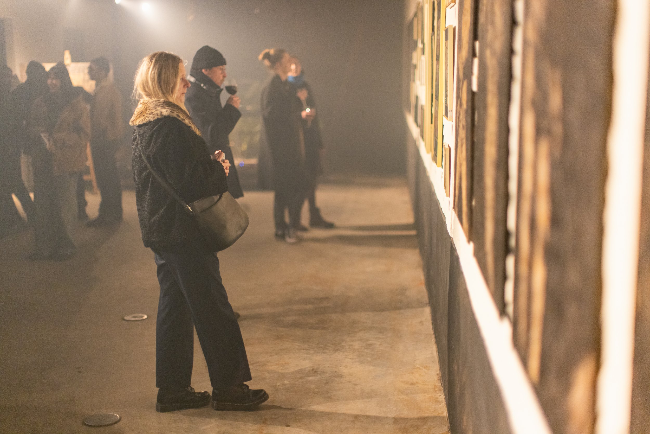 People viewing artwork at an art gallery or exhibition.