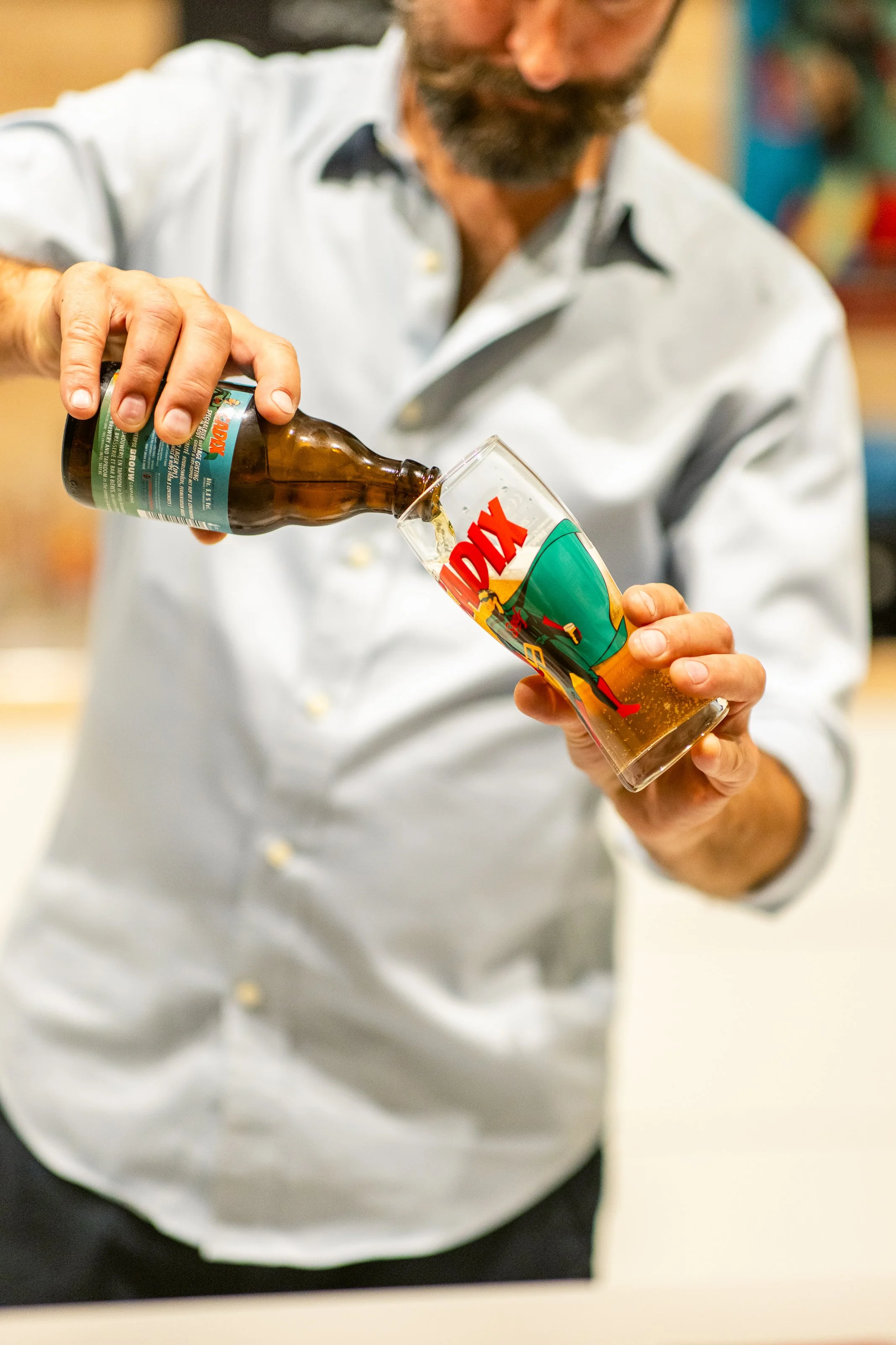 A man pouring beer into a glass with a 'TARDIS' design from Doctor Who.
