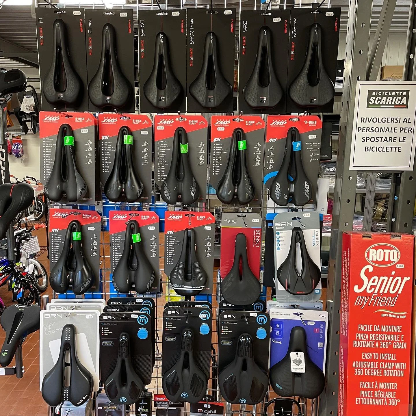 Selezione di selle per biciclette esposte su un scaffale in negozio a Parma.