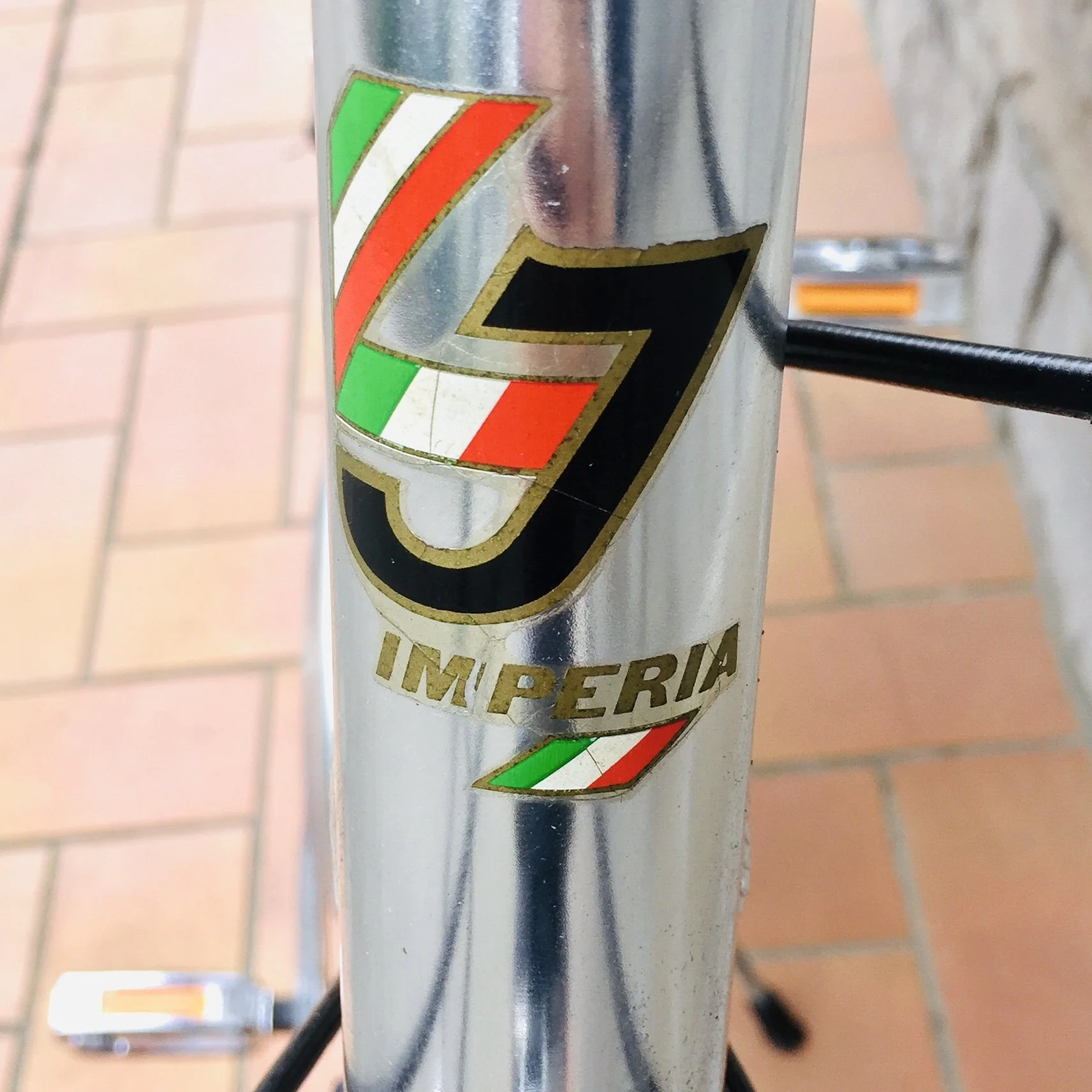 Logo della impresa Impéria su un telaio di bicicletta, con colori della bandiera italiana.