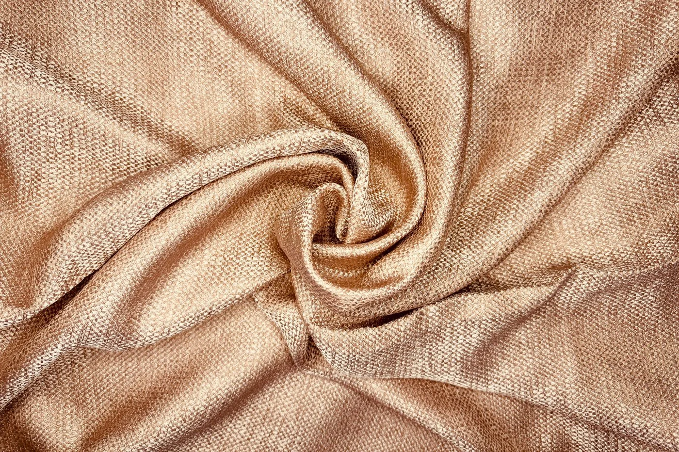 A beige curtain with soft lighting creating gentle shadows and folds.