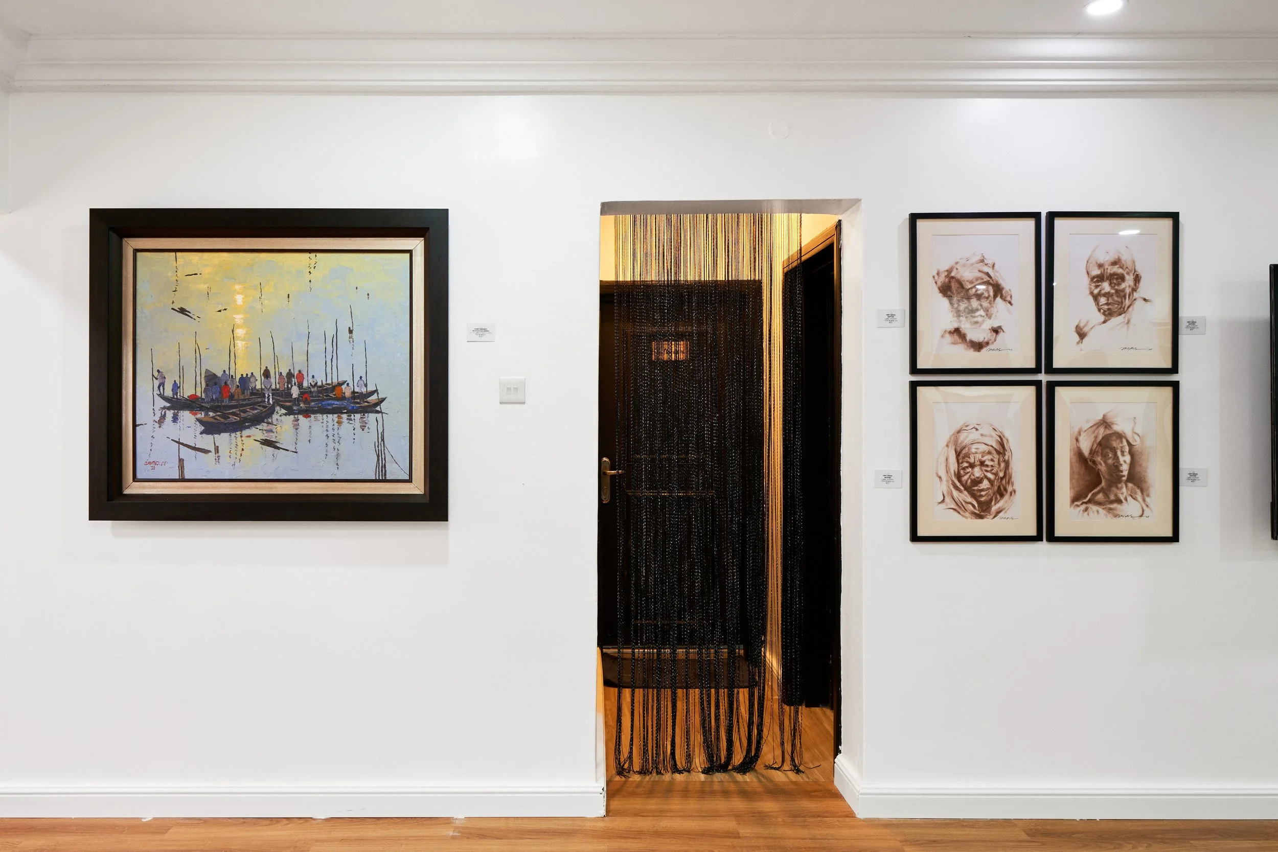 Art gallery with a boat painting on the left and four portrait sketches on the right, with a beaded curtain doorway in the center.