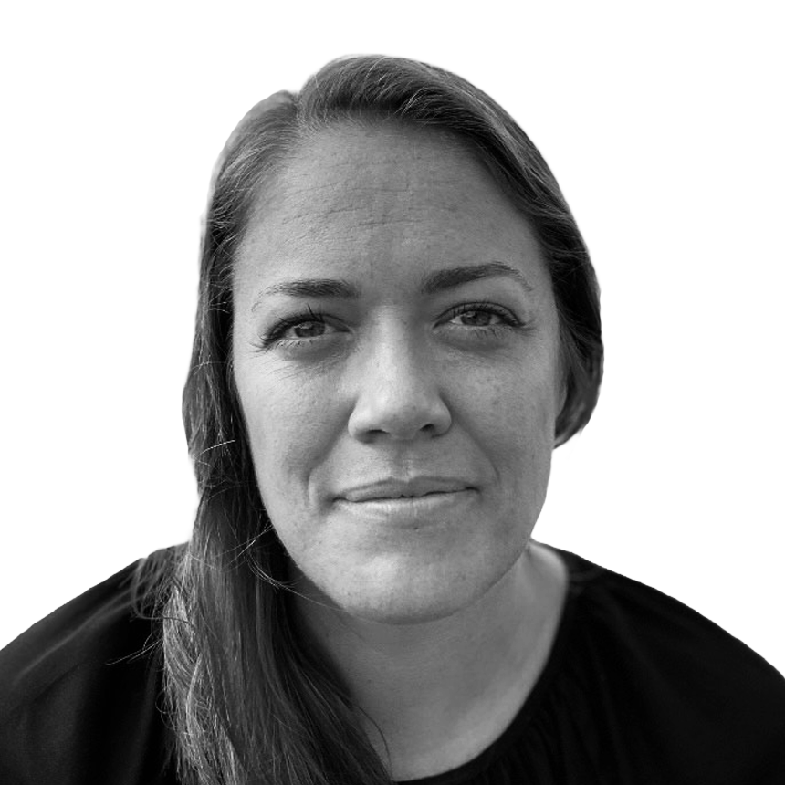 Close-up black and white portrait of a woman with long hair, slight smile, looking directly at the camera, plain white background.