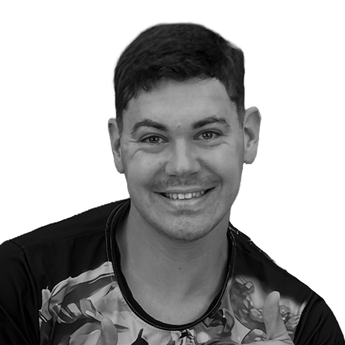 Smiling young man with short dark hair, wearing a patterned shirt, giving a thumbs-up pose against a plain background.