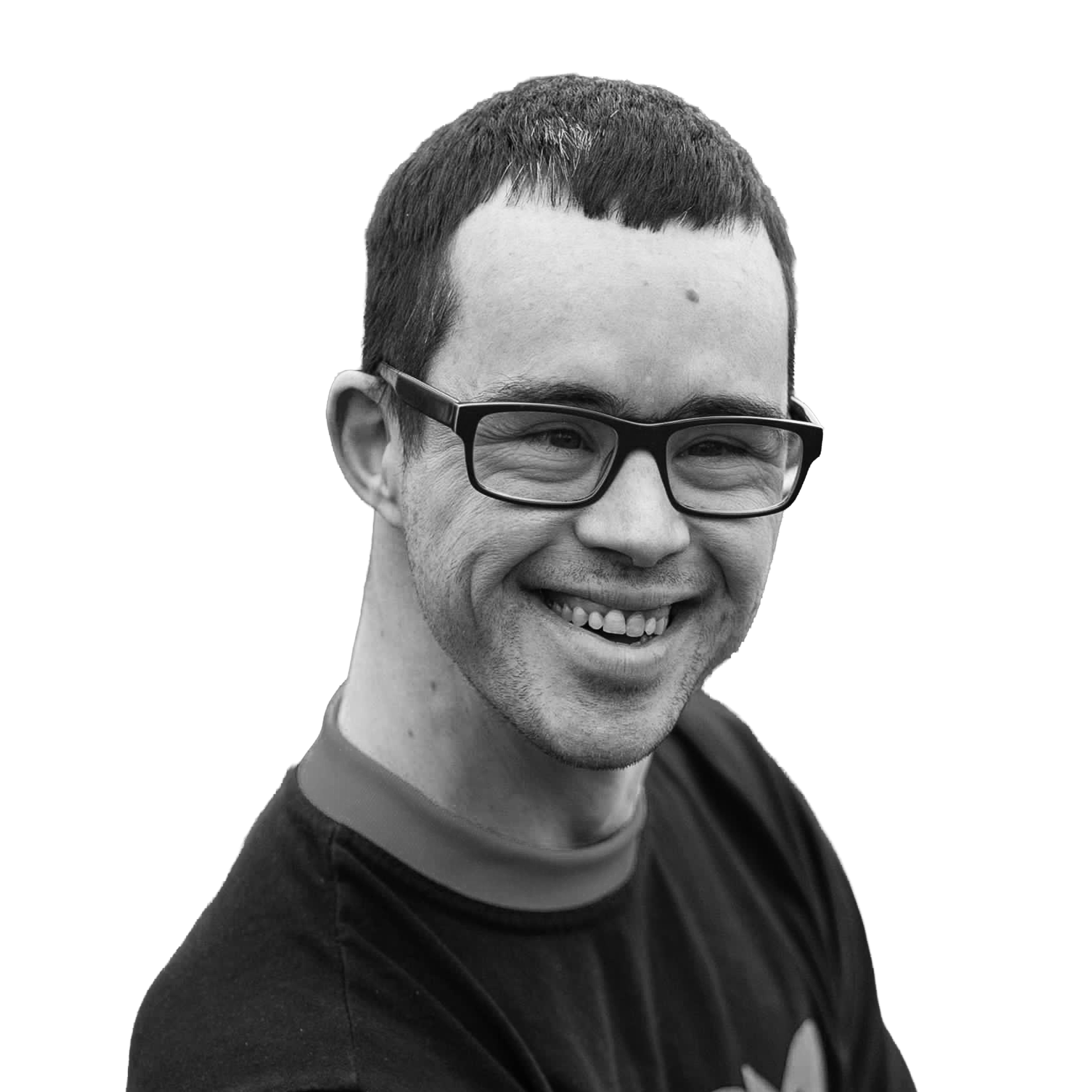 Black and white photo of smiling man wearing glasses, short dark hair, and a casual shirt.