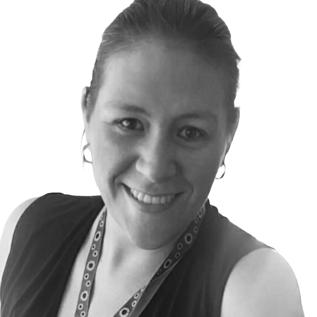 Black-and-white photo of a smiling woman with short hair, wearing earrings, a sleeveless top, and a lanyard around her neck, against a plain light background.