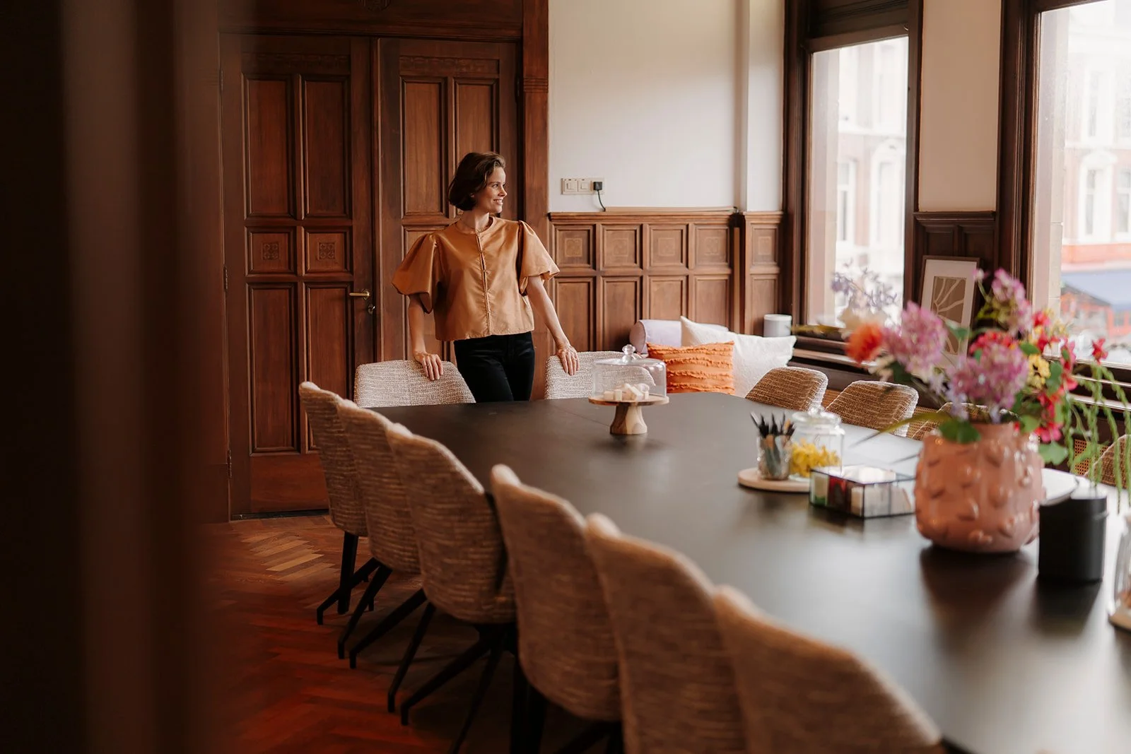 Vrouw, oprichter BoldSpace, in de vergaderlocatie waar een heisessie gegeven kan worden. Op de foto zie je een vergadertafel met stoelen.