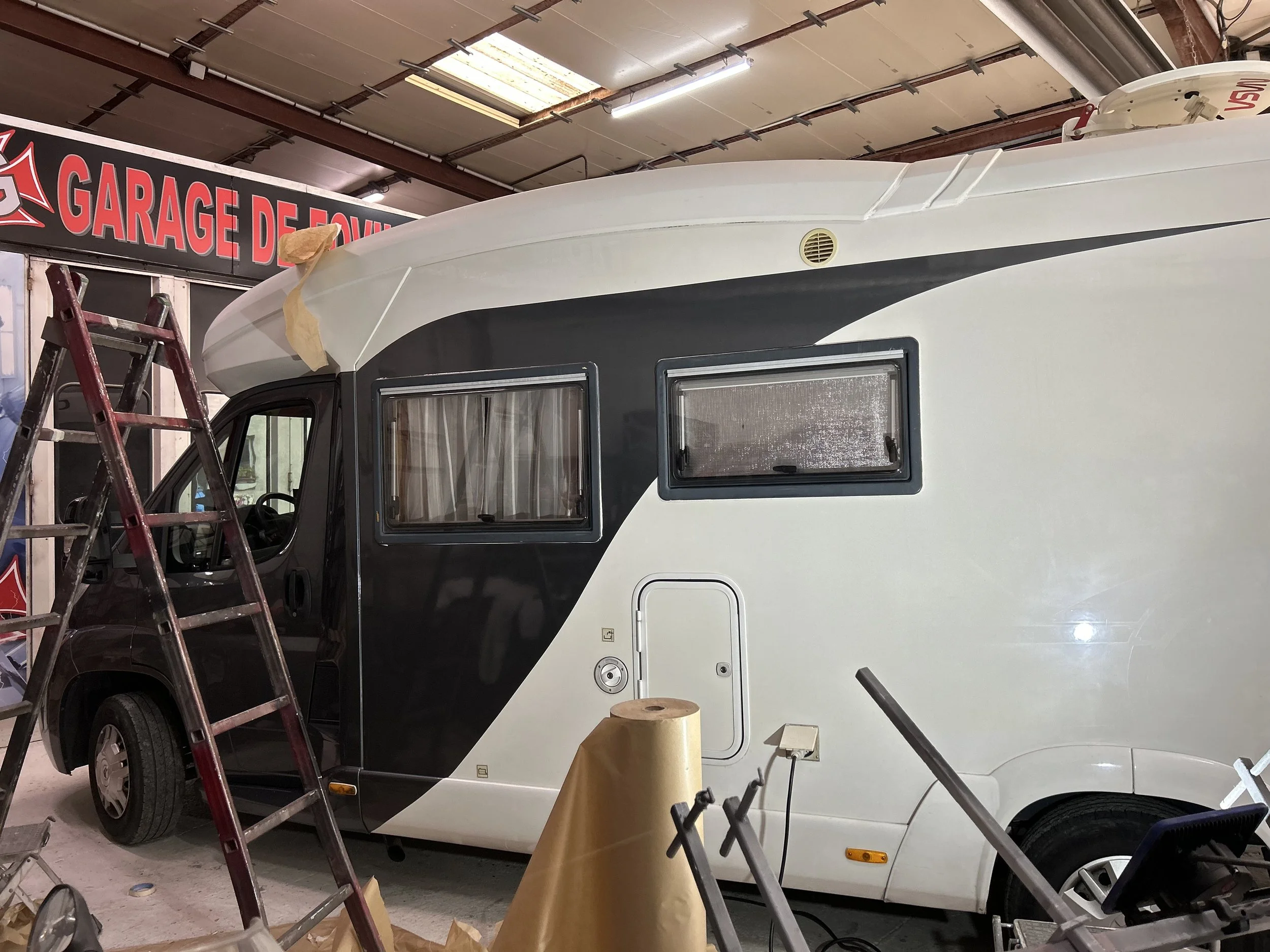 Véhicule de camping en intérieur, en cours d'entretien ou de réparation, dans un garage.