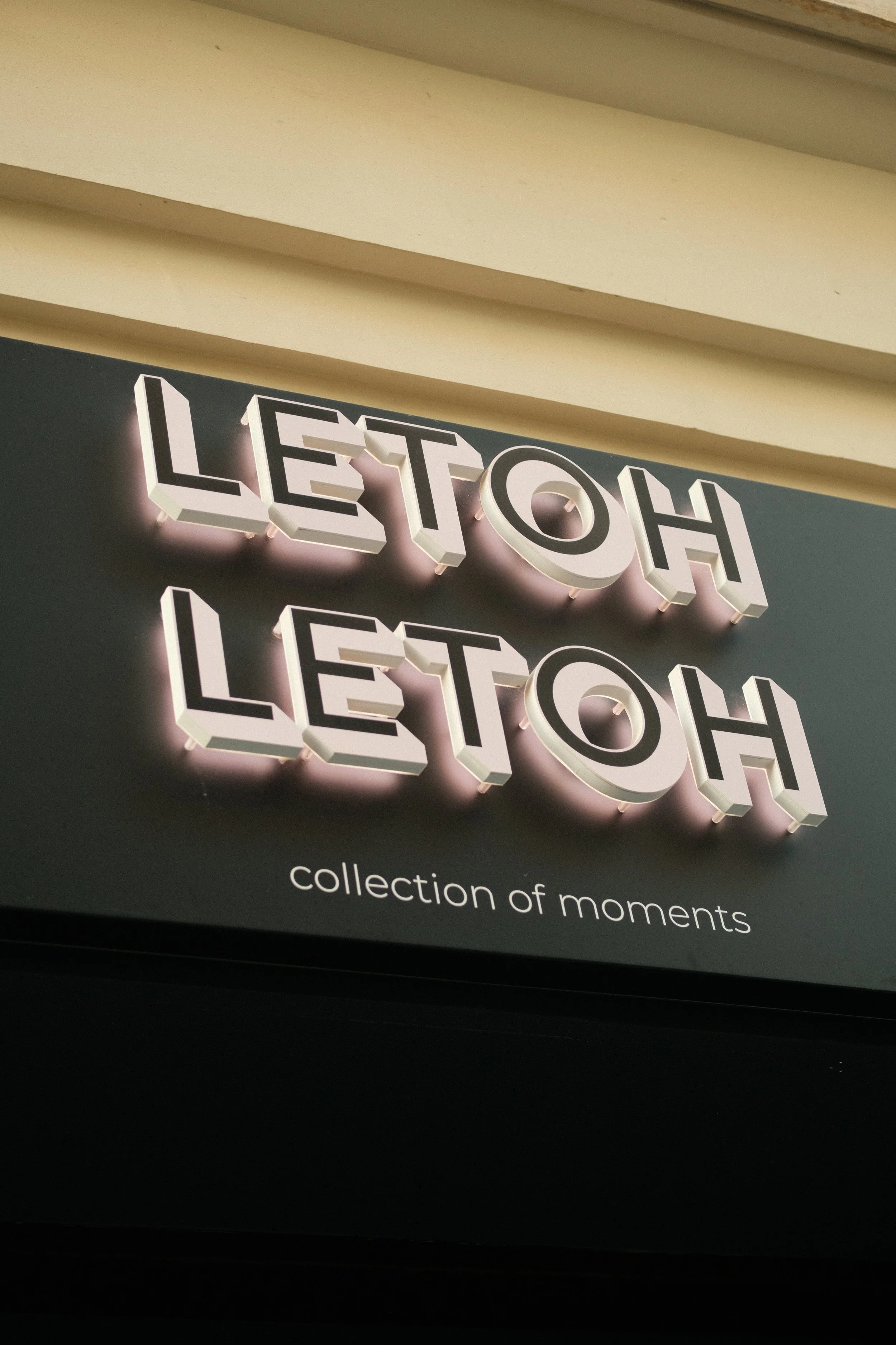 Sign with the words 'LETOH LETOH' in 3D illuminated letters, with the subtitle 'collection of moments' below.