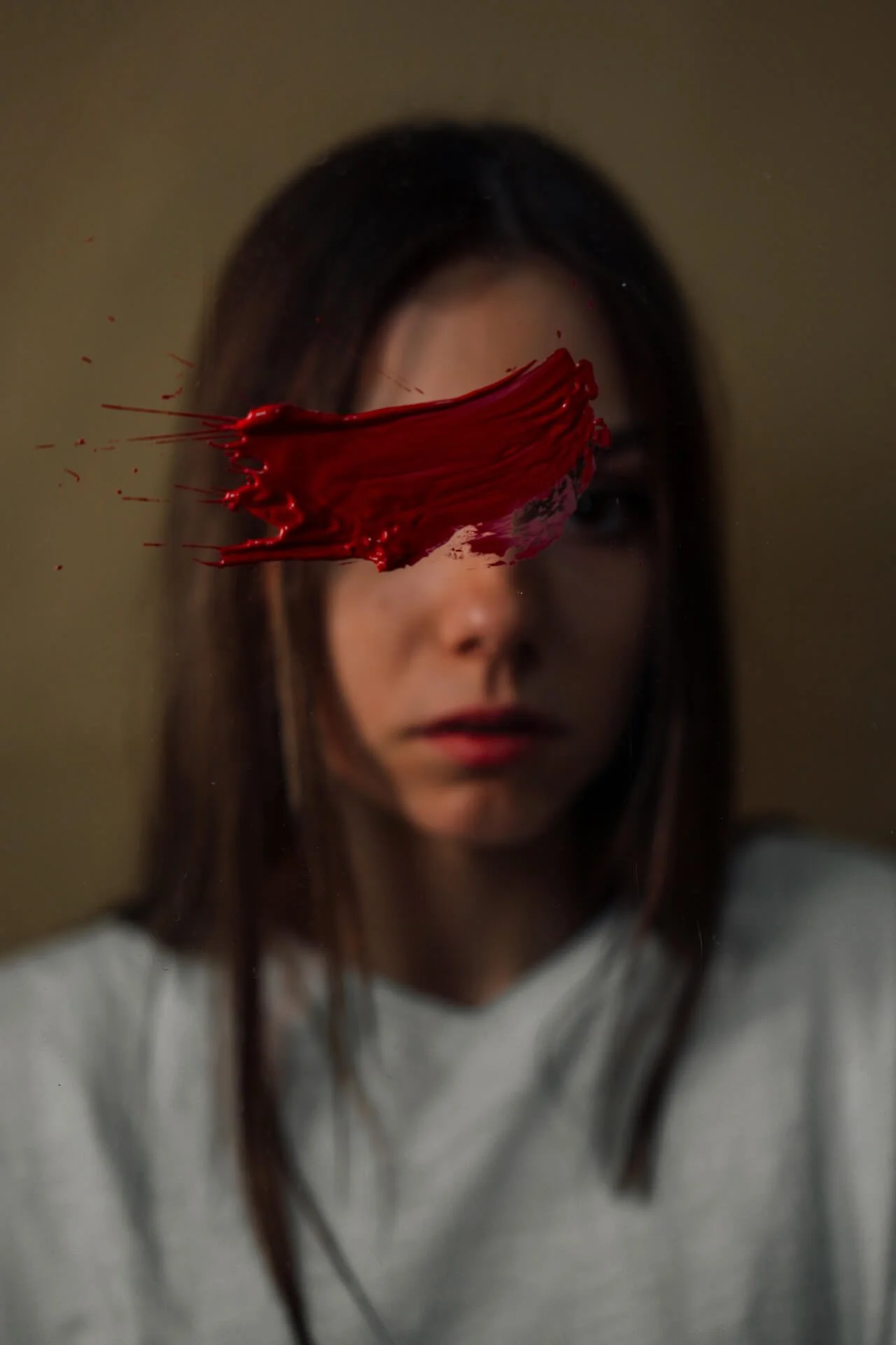 Mujer foto en el espejo con pintalabios rojo en la pared tapandola los ojos