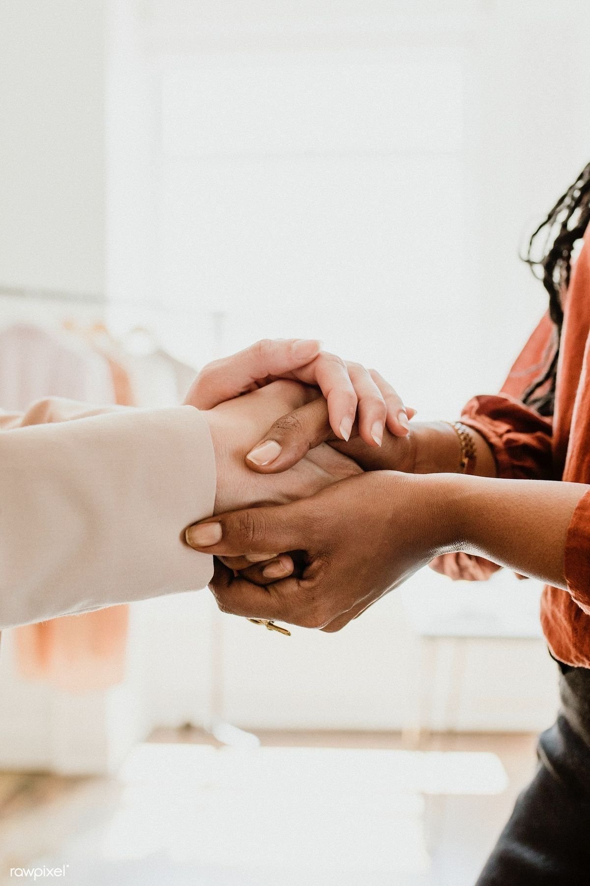 Female doctors holding hands with patient to show strength, unity, and compassion in their healing