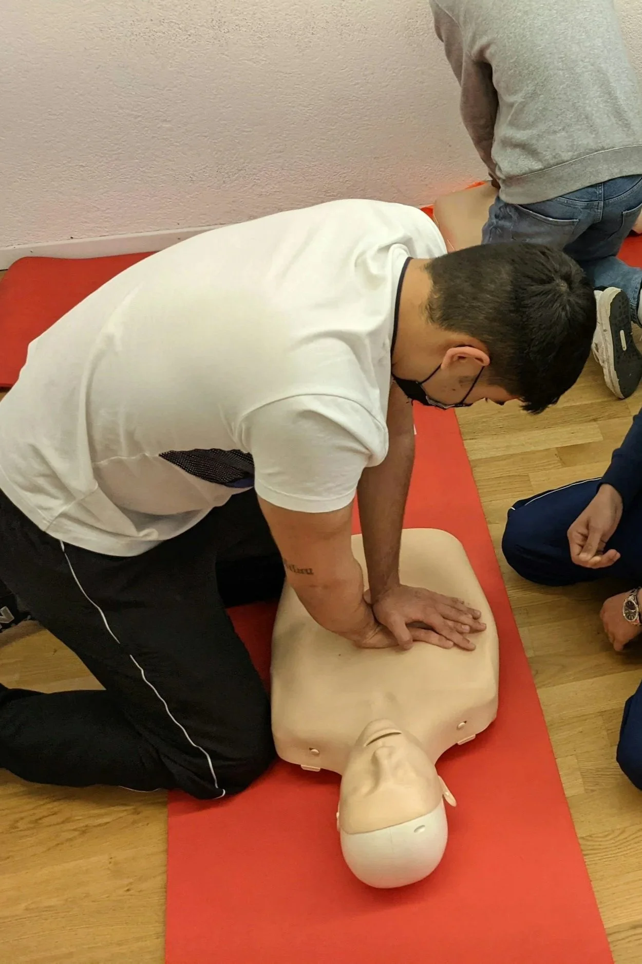 Une personne effectuant un massage cardiaque sur un mannequin pour la formation en secourisme, lors d'une session de formation.