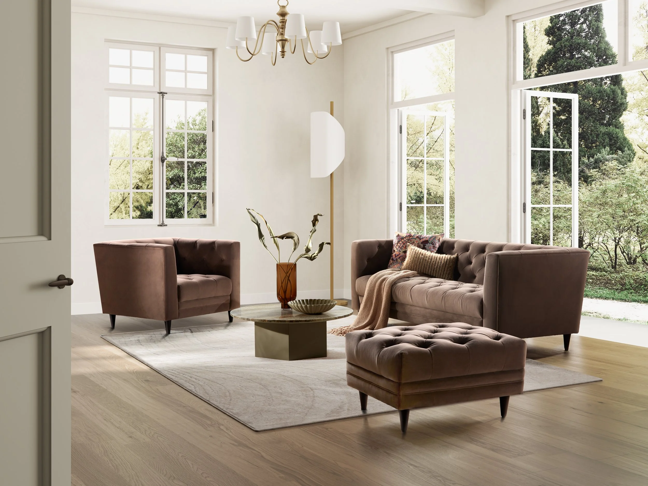 Bright living room with large windows, beige walls, a chandelier, two Nest Space mauve sofas, a matching ottoman, a beige area rug, a round coffee table with a sculpture and bowl, a tall floor lamp, and view of greenery outside.