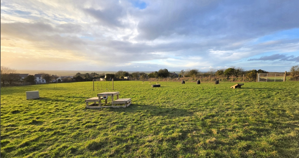 Fully enclosed dog exercise field with agility equipment at Atlantic View Farm Dog Field, Cornwall