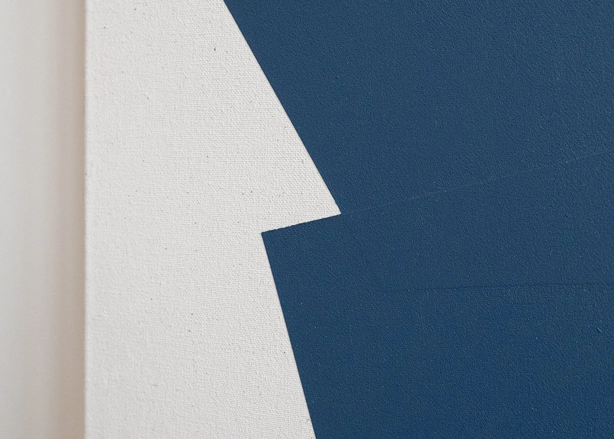 Close-up of a textured wall with white and dark blue paint, featuring a geometric pattern.