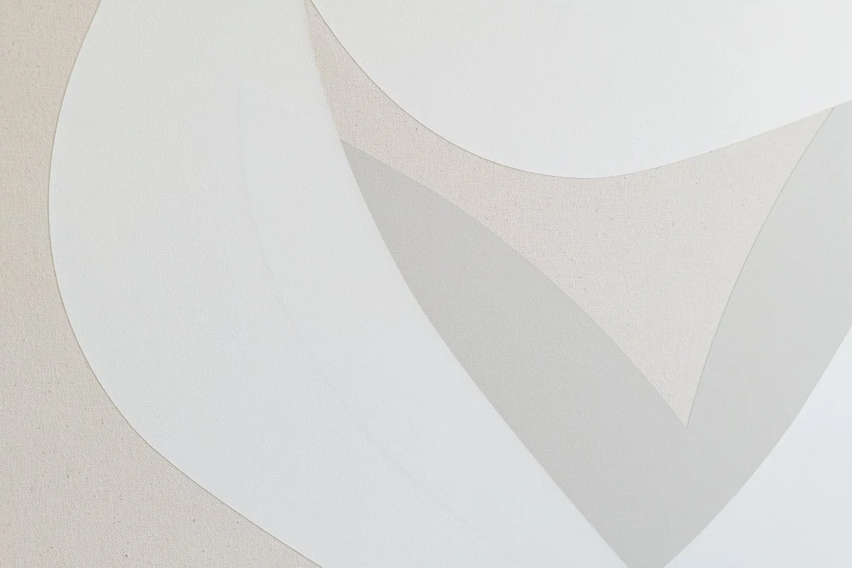Close-up of a white, textured surface with overlapping paper or material cutouts forming an abstract geometric pattern.