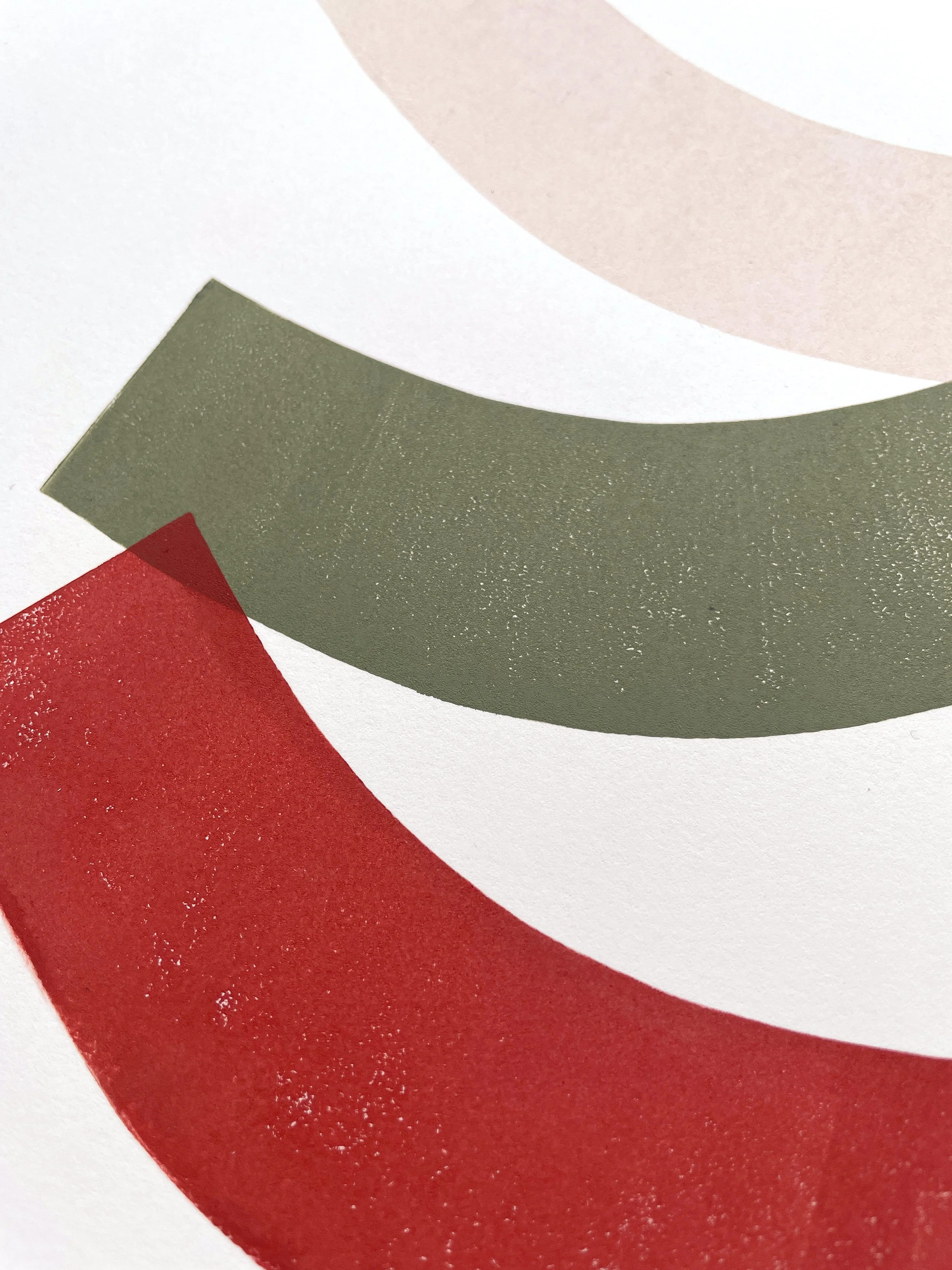 Close-up of abstract geometric shapes in red, green, and muted pink colors.