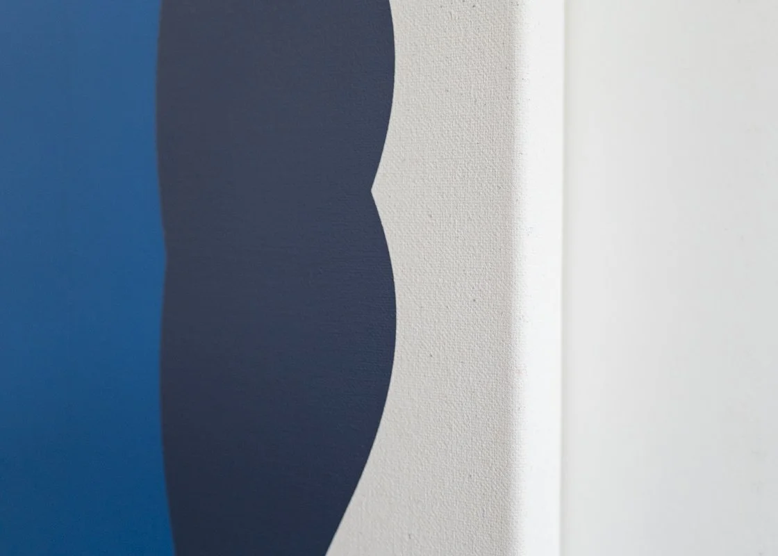Close-up of wall with abstract painted shapes in blue and dark gray colors.