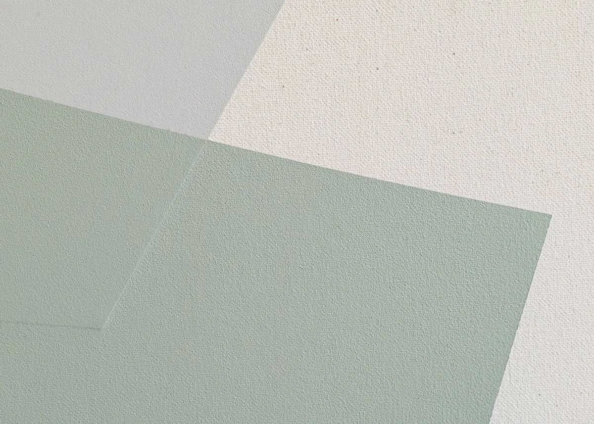 Close-up of textured paper surfaces in light green and off-white colors.