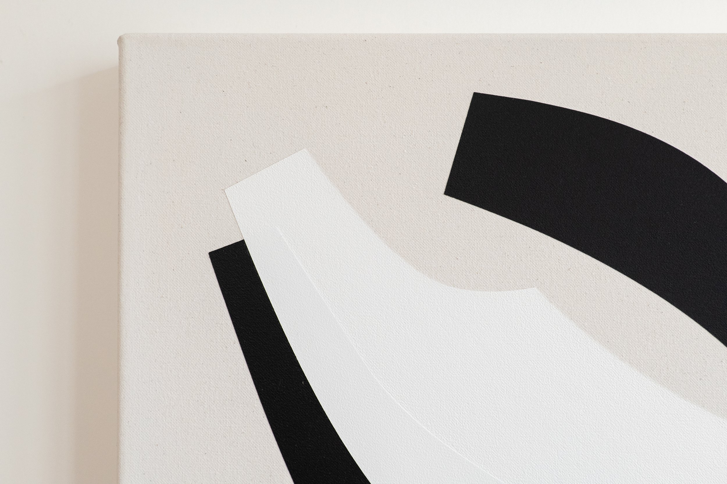 Close-up of a minimalist abstract painting with black and white geometric shapes on a textured off-white canvas.