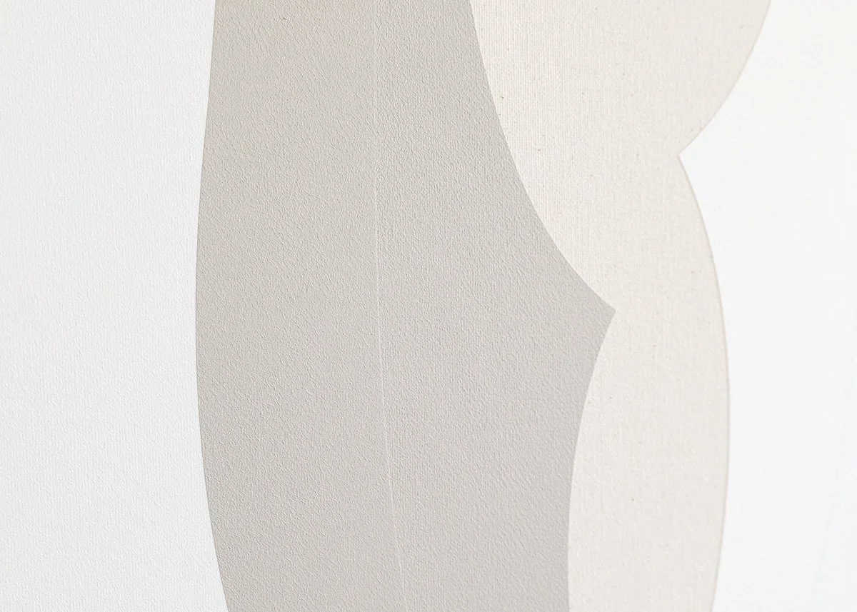 Close-up of a textured white wall with an abstract pattern of light and shadow.