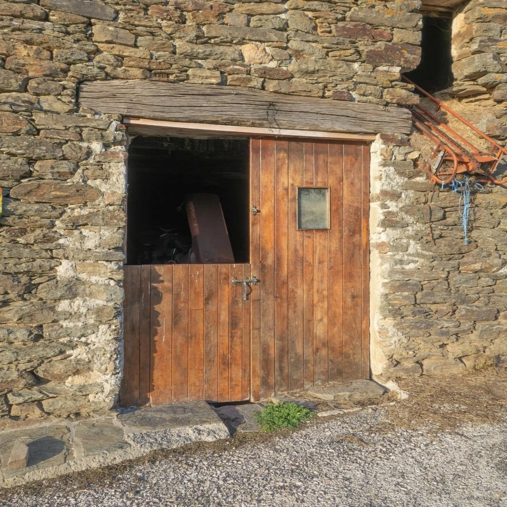 A wooden door on a stone barn.