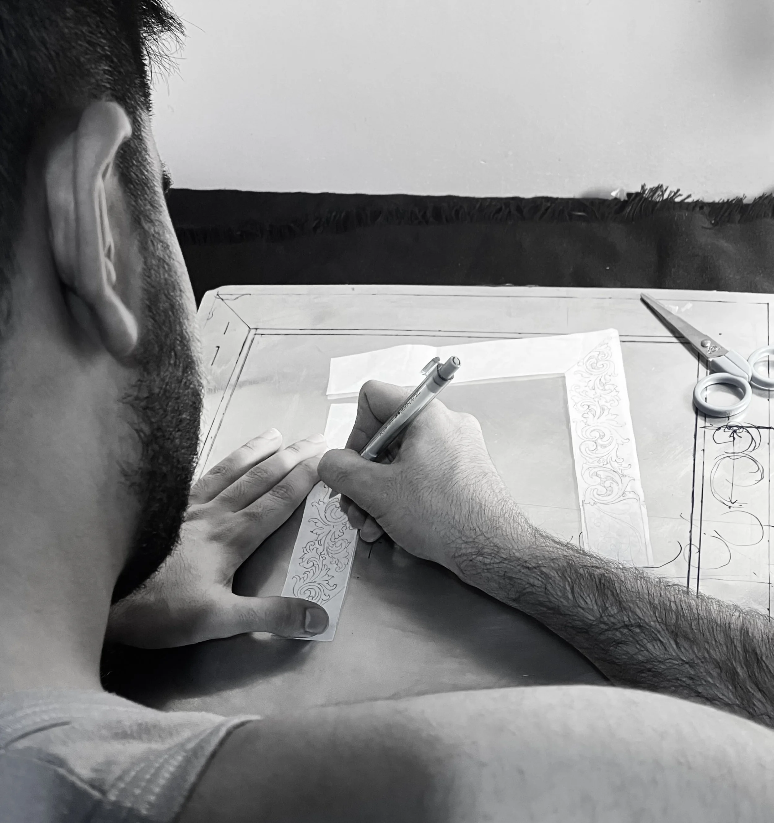 Parandeh hand-sketching his metalworks and raw sculptures