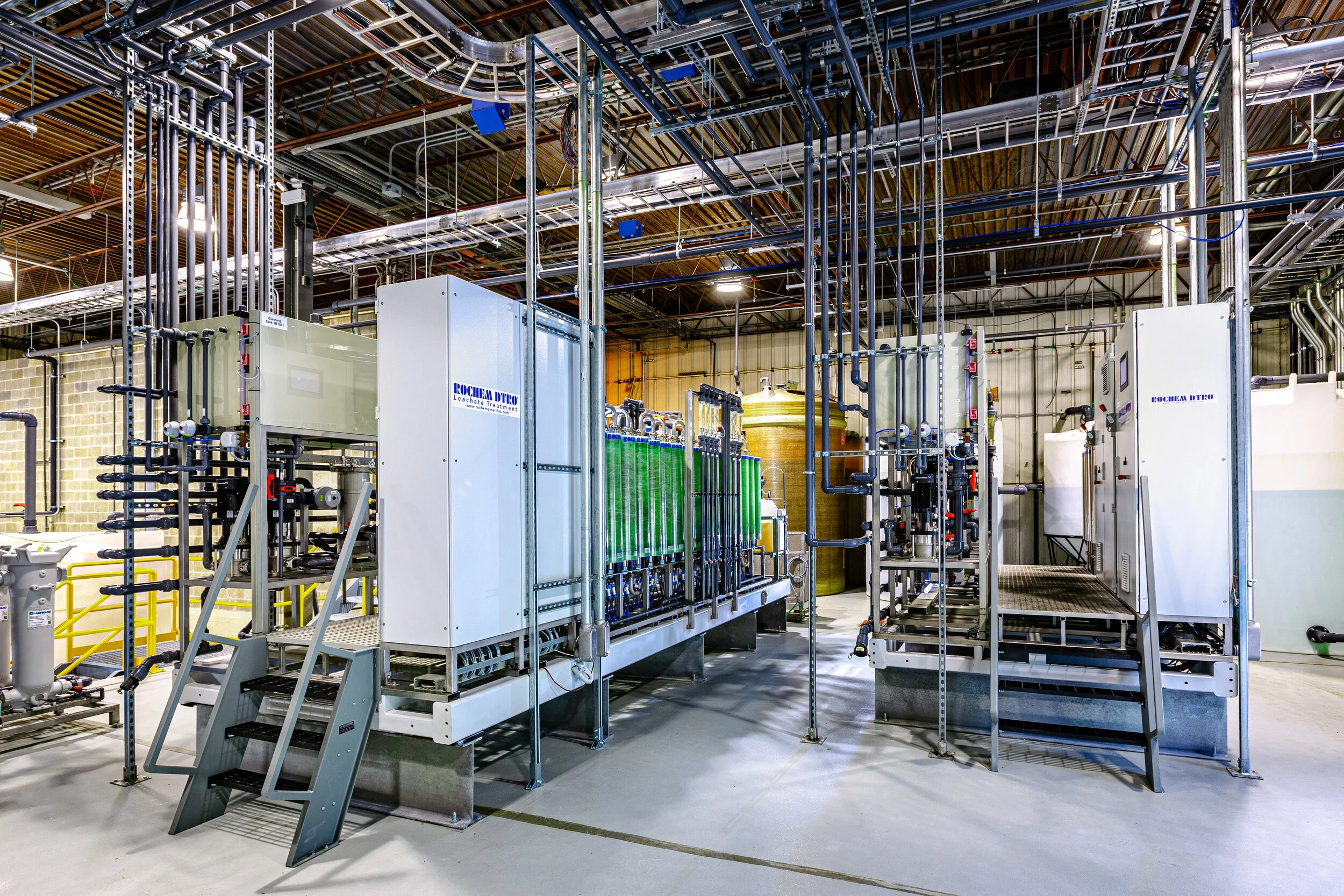 Industrial facility featuring complex piping and machinery setup with elevated platforms and advanced equipment.