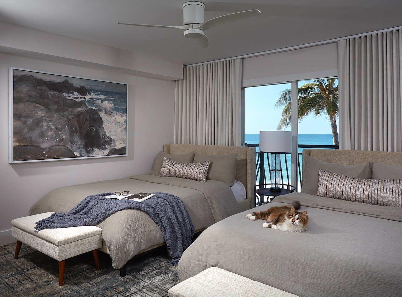 gulfshore-getaway-bedroom-ocean-view-soft-green-layered-bedding-cat-gloria-black-design.jpeg