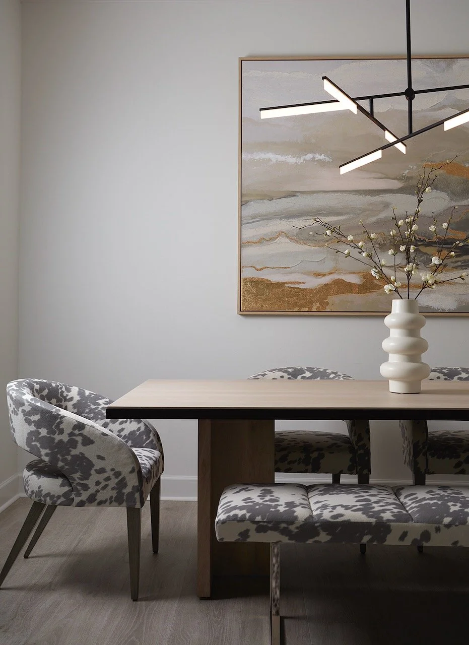 Golden Grotto dining room by Gloria Black Design sculptural cowhide upholstered dining chairs and bench light oak slab table abstract gold leaf landscape painting geometric black linear pendant luxury contemporary interior design Naples Florida