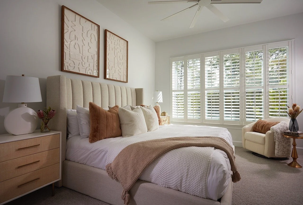 golden-grotto-primary-bedroom-upholstered-headboard-terracotta-accents-plantation-shutters-gloria-black-design.jpeg