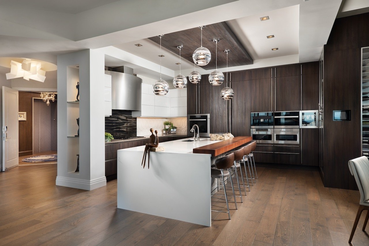 modern-penthouse-kitchen-dark-wood-cabinets-white-island-pendants-bonita-springs-gloria-black-design.jpeg