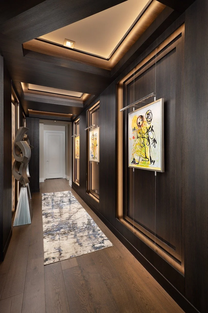 modern-penthouse-entry-dark-wood-paneling-gallery-art-dramatic-lighting-gloria-black-design.jpeg