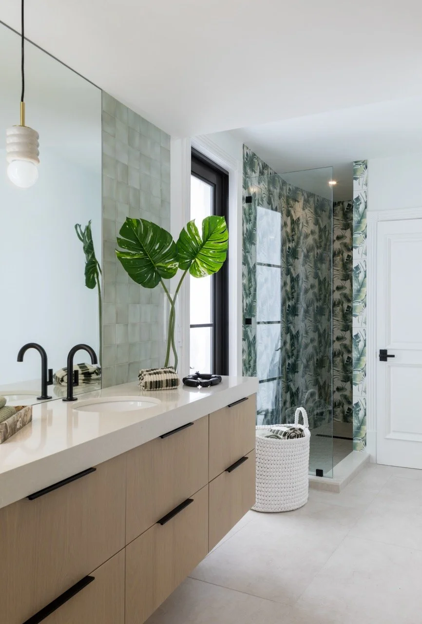 Writer's Repose spa bathroom by Gloria Black Design — sage green zellige tile, floating custom vanity, monstera plant, matte black fixtures, and biophilic wellness design in a Naples Florida luxury residence