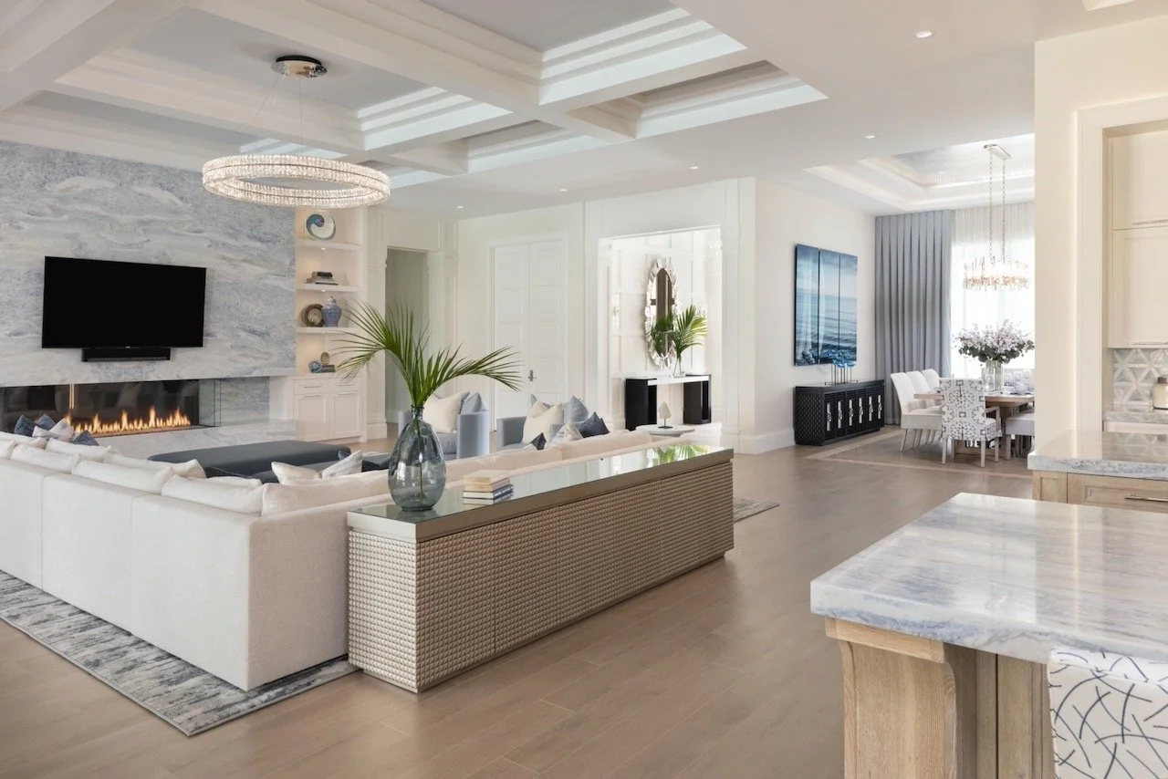 New England Charmer living room with coffered ceiling, ring chandelier, marble fireplace and custom built-ins — Gloria Black Design Naples Florida