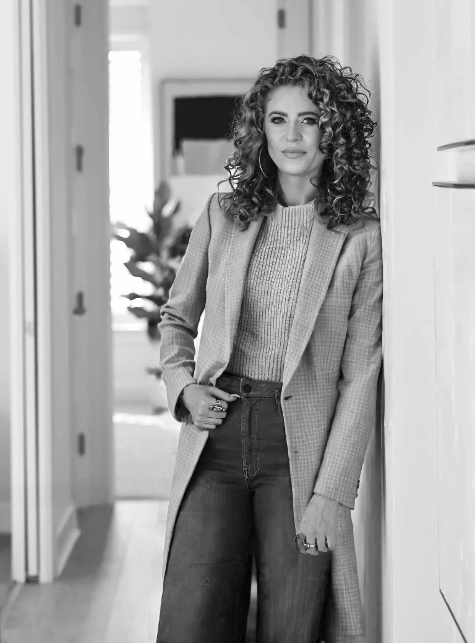 Gloria Black, award-winning luxury interior design consultant and creative strategist — professional portrait in light blazer surrounded by tropical greenery, Naples Florida