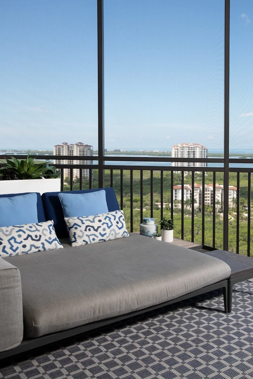 modern-penthouse-balcony-gray-sofa-blue-pillows-geometric-tile-bonita-springs-gloria-black-design.jpeg