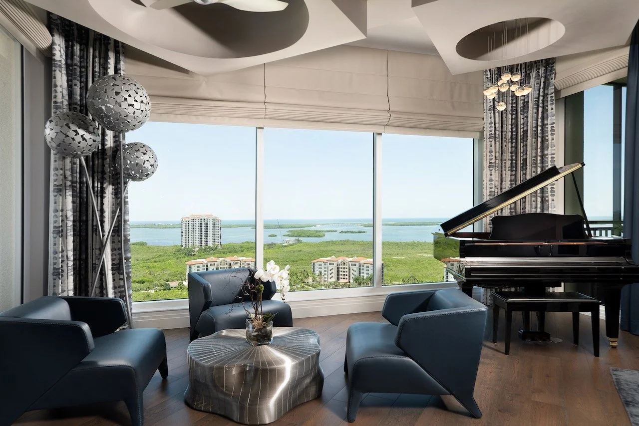 modern-penthouse-piano-room-grand-piano-blue-lounge-chairs-panoramic-water-views-gloria-black-design.jpeg