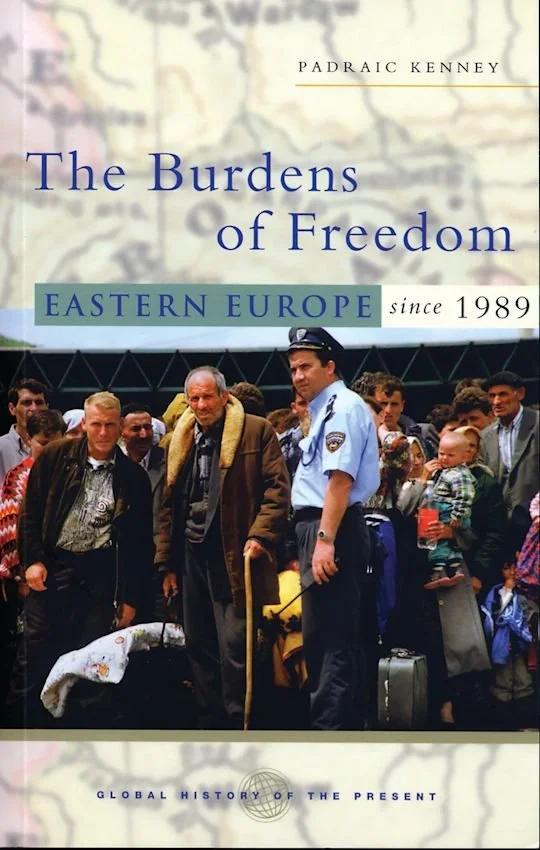 Book cover titled "The Burdens of Freedom: Eastern Europe since 1989" by Padraic Kenney, featuring a group of people, including a uniformed officer, at an airport or border crossing with a map background.