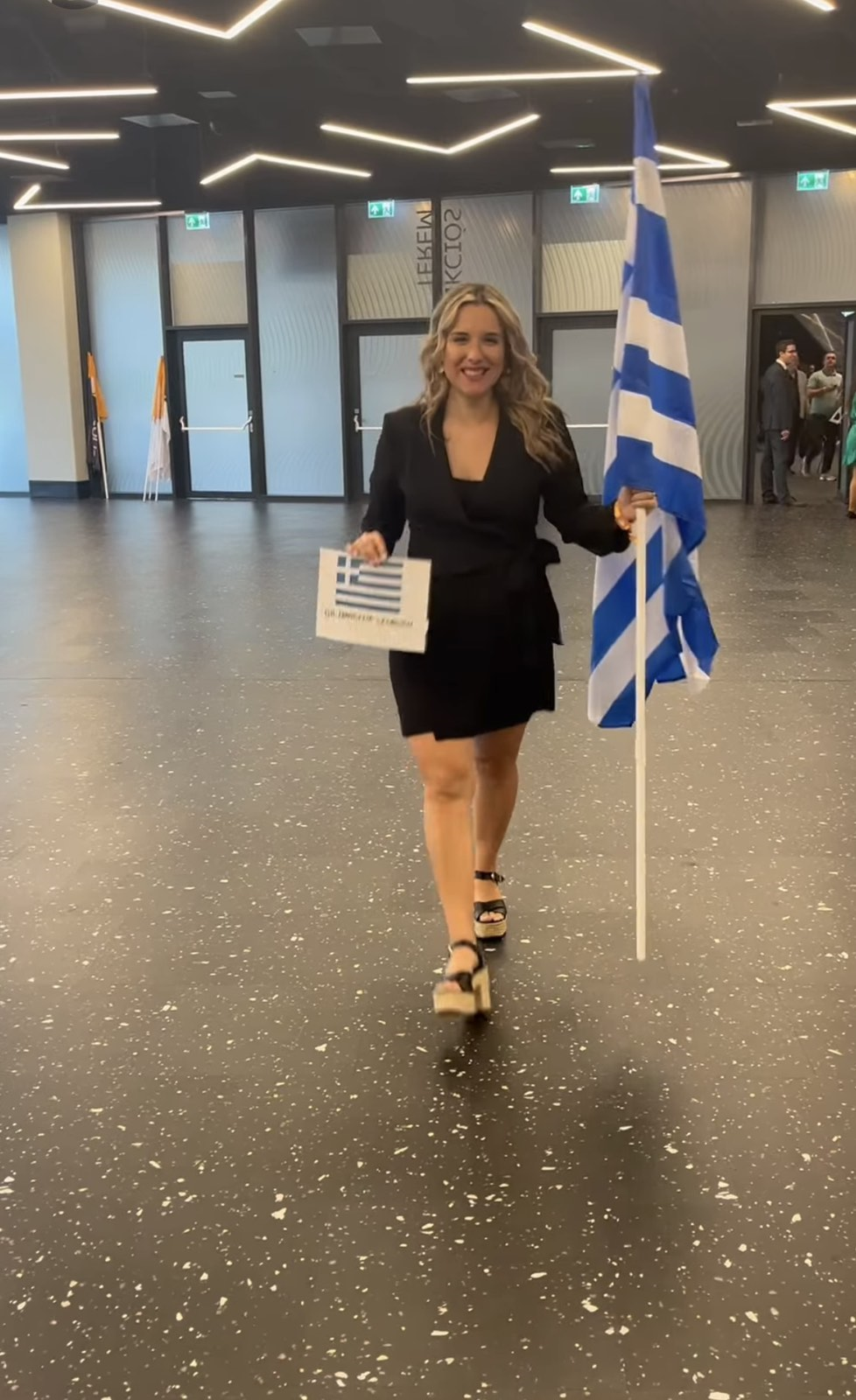Evi Georgiou holding a certificate in a professional indoor setting